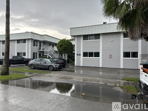 A car is parked in front of a building with the number 6368 on it.