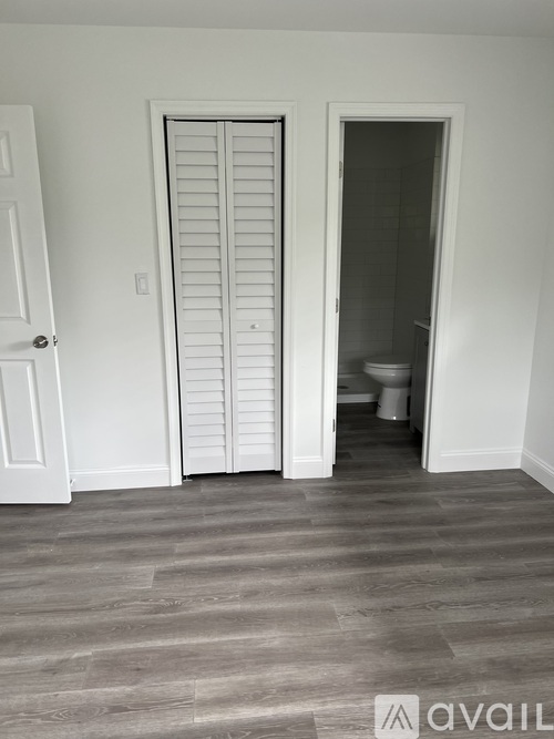 A room with a white door and a white closet.