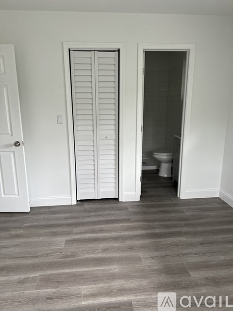 A room with a white door and a white closet.