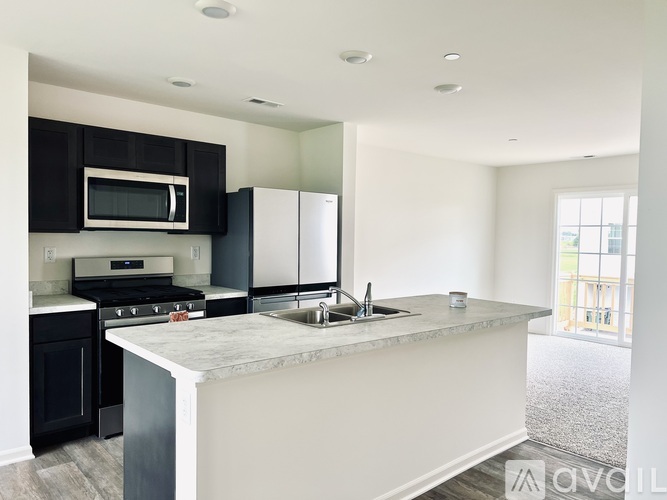 A kitchen with black cabinets and stainless steel appliances.