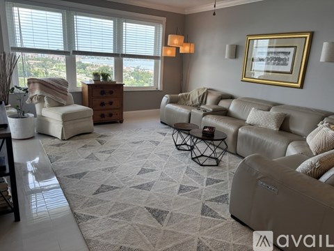 A living room with a grey sofa and a black metal table.
