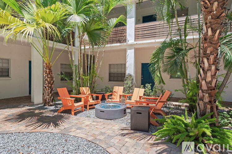 A patio with a hot tub surrounded by palm trees.