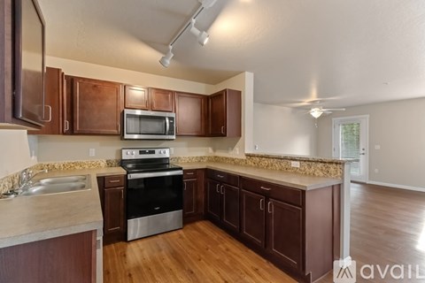 A kitchen with brown cabinets and a stainless steel oven.