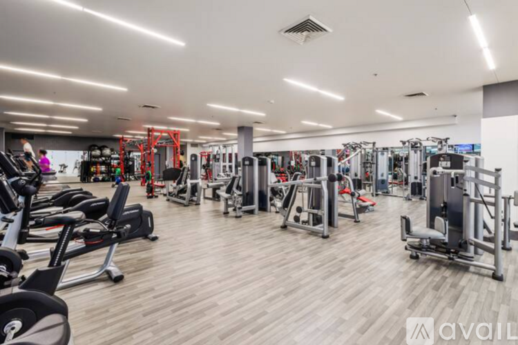 A gym with a variety of equipment including treadmills, weights, and exercise machines.