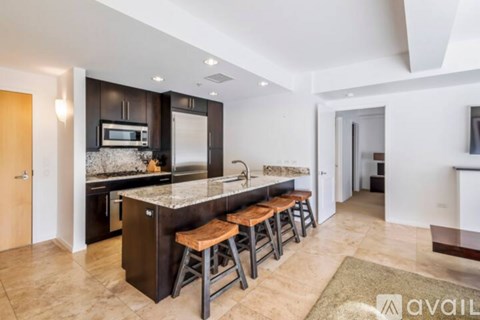 A kitchen with a bar stool and a counter top.