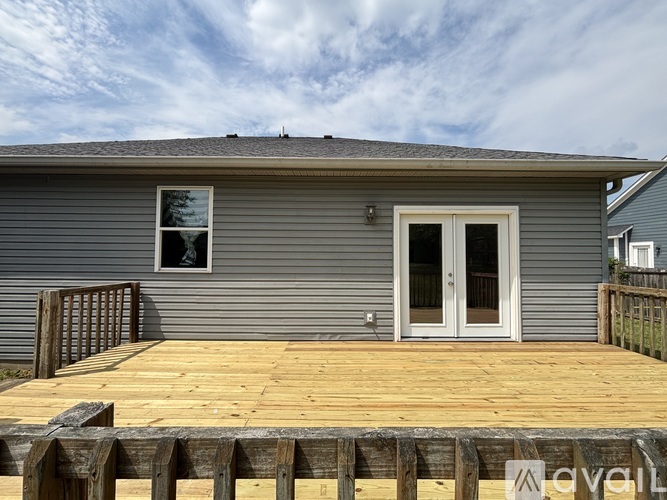 A house with a grey exterior and a wooden deck.