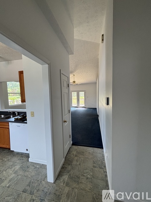 A kitchen with a sink and a doorway leading to another room.