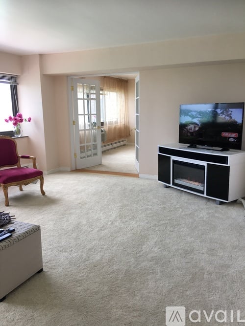 A living room with a red chair and a television.