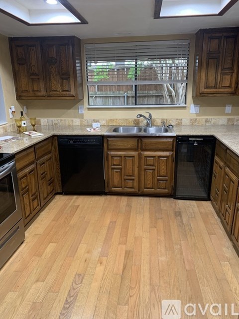 A kitchen with wooden cabinets and black appliances.
