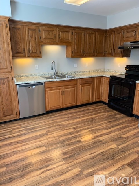 A kitchen with wooden cabinets and a black oven.