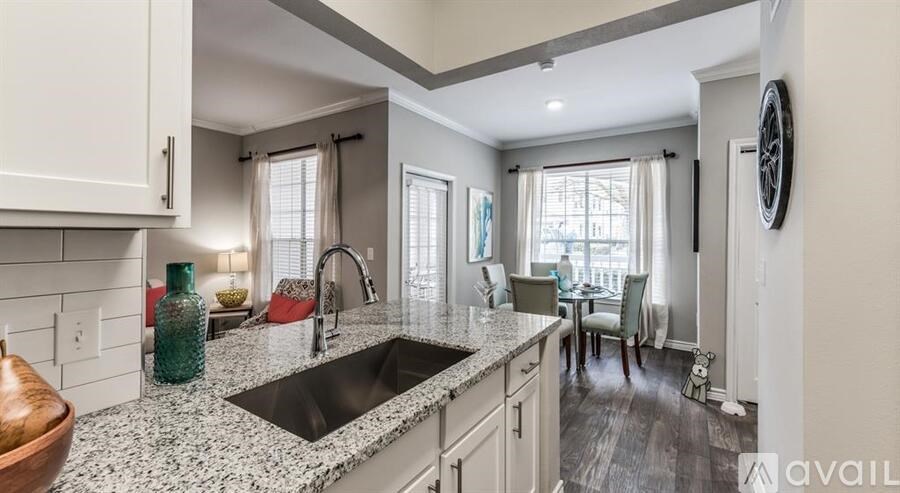 A kitchen with granite countertops and a view of the dining area.
