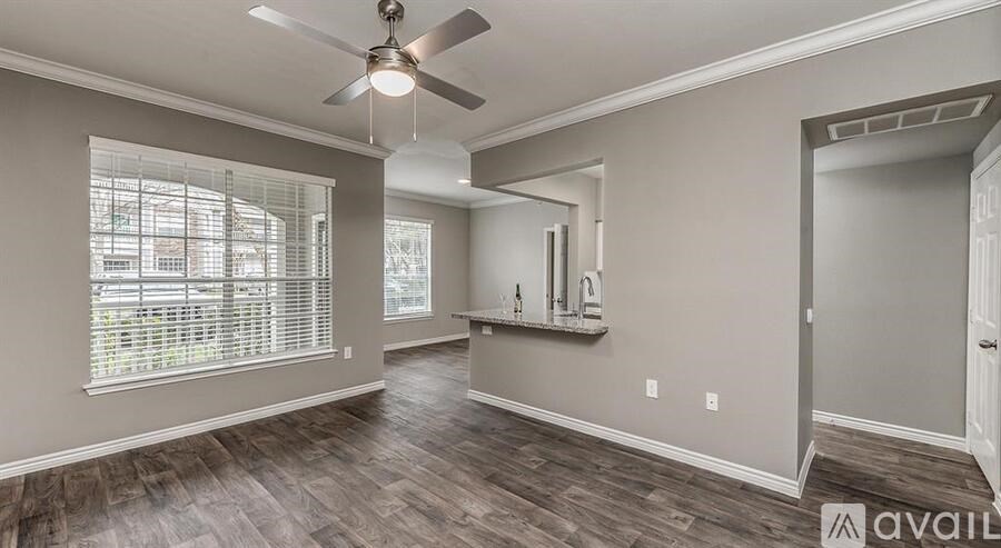 A spacious room with a ceiling fan and wood flooring.