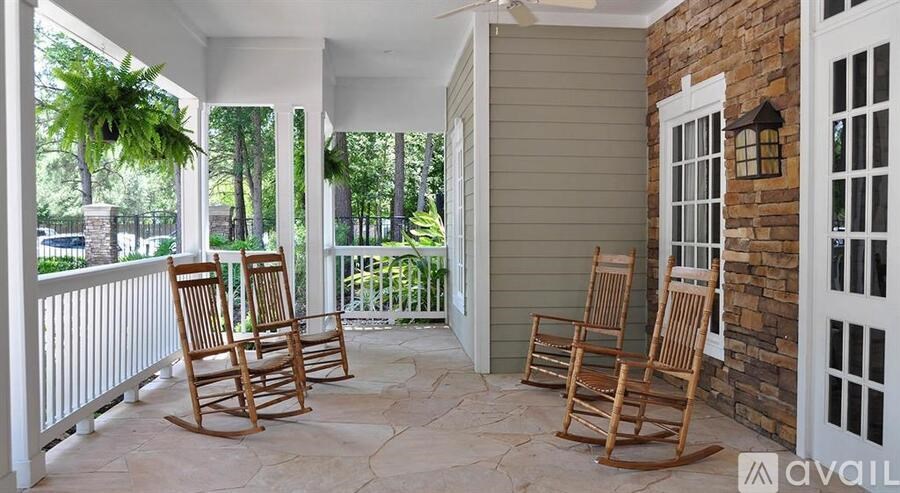 Three rocking chairs are on a porch.