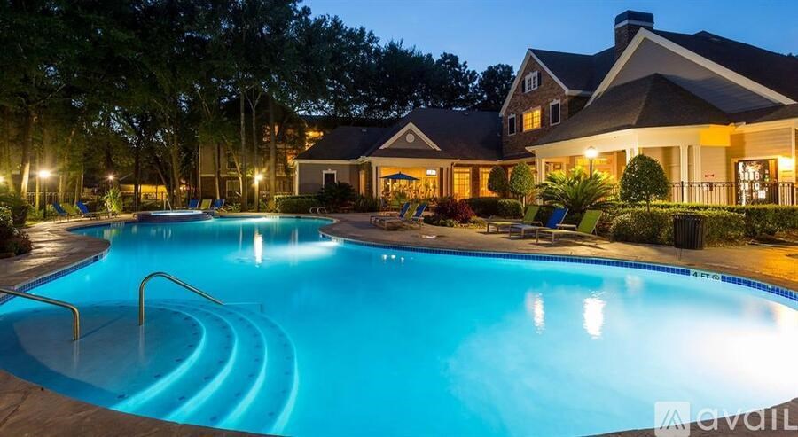 A large residential house with a swimming pool at night.