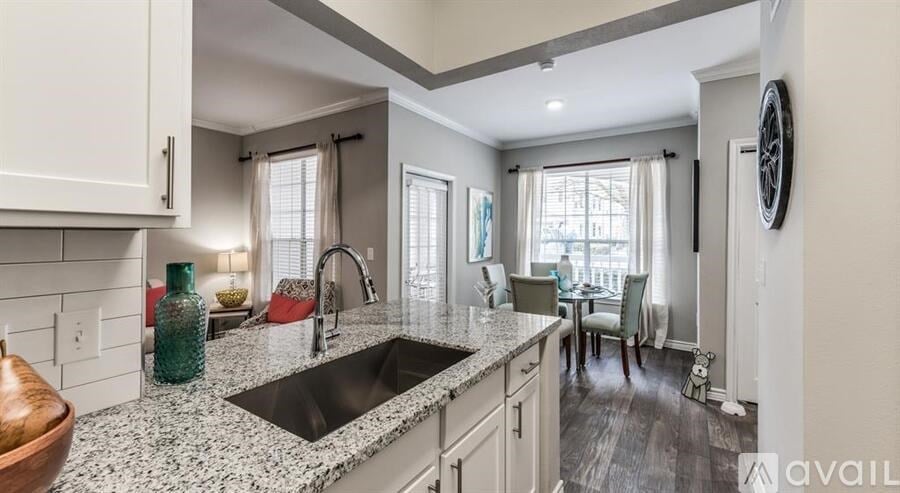 A kitchen with granite countertops and a view of the dining area.