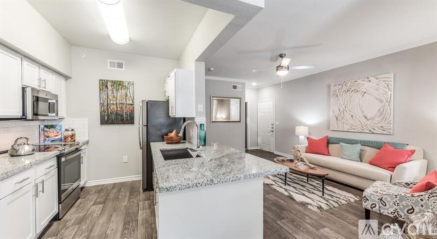 A modern kitchen with white appliances and a marble island.