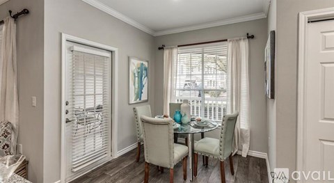 A dining room with a table set for four.
