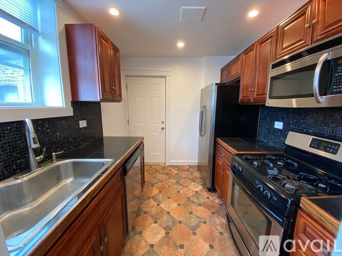 A kitchen with wooden cabinets and black appliances.