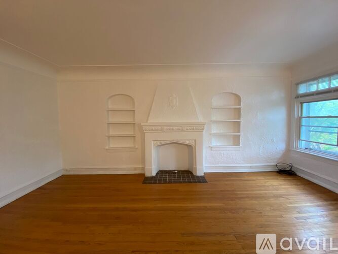 A room with a fireplace and wooden floors.