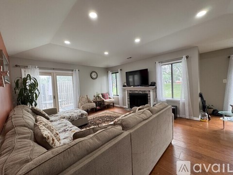 A living room with a large couch and a fireplace.