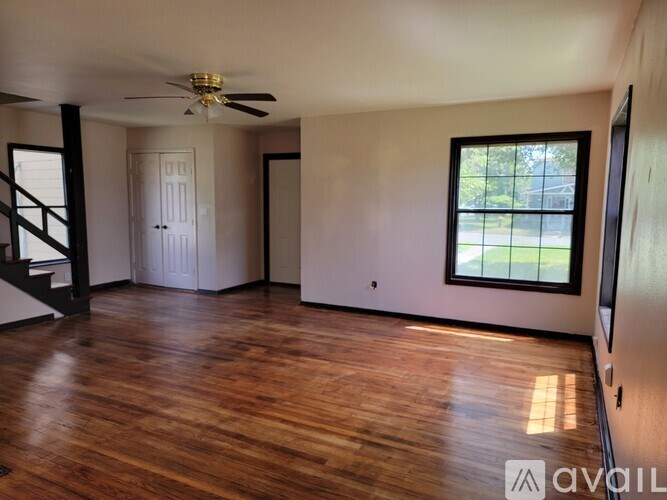 A room with wooden floors and a ceiling fan.