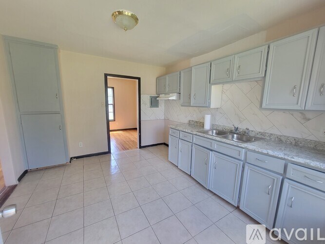 A kitchen with white cabinets and a marble countertop.