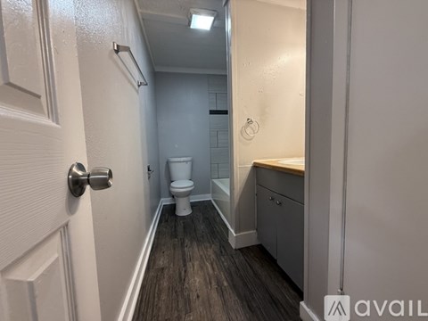 A room with wooden flooring and a window with blinds.