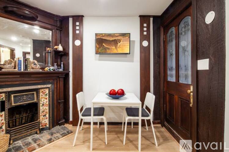 A dining room with a fireplace and a painting on the wall.