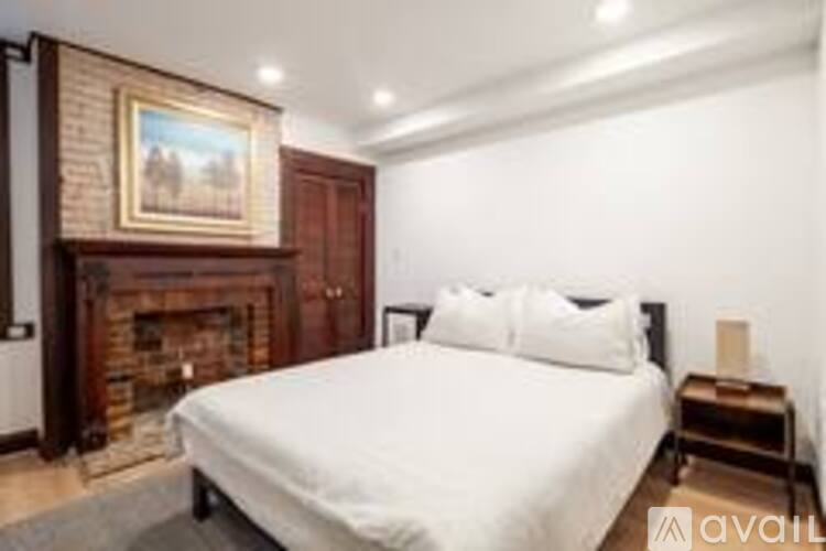 A bedroom with a large bed and a fireplace.