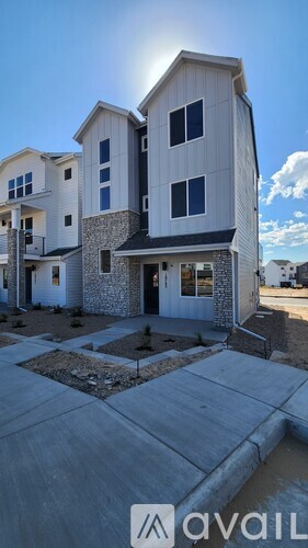 A modern house with a stone facade and a large front yard.