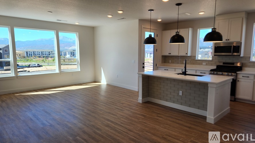 A kitchen area with a counter and a window overlooking a parking lot.