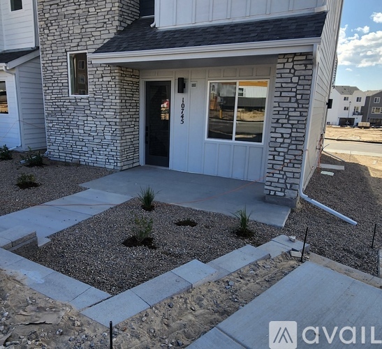 A house with a stone wall and a black door.