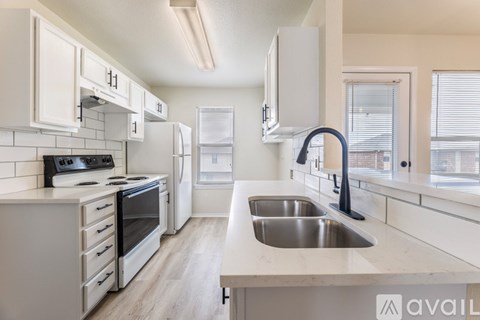 A kitchen with white cabinets and a stove top oven.