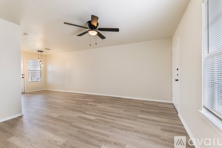 A spacious room with a ceiling fan and lighting fixtures.