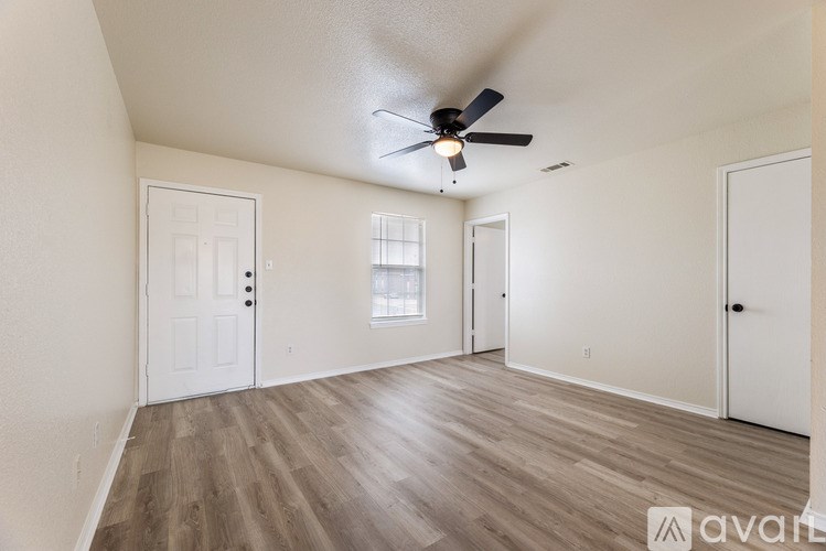 A room with a ceiling fan and wooden flooring.