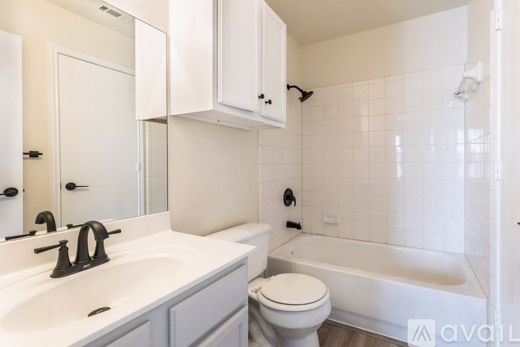 A white bathroom with a toilet, sink, and bathtub.