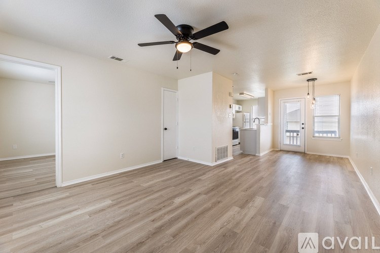 A spacious room with a ceiling fan and light fixture.