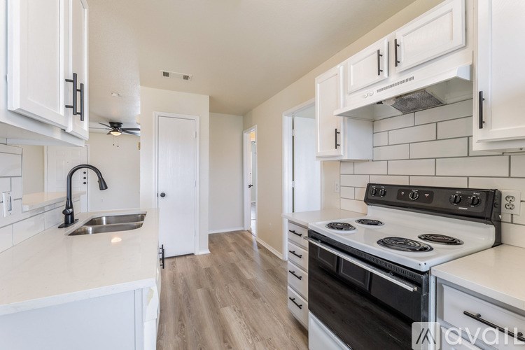 A kitchen with white cabinets and a black stove top oven.