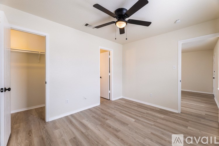 A room with a ceiling fan and wooden flooring.
