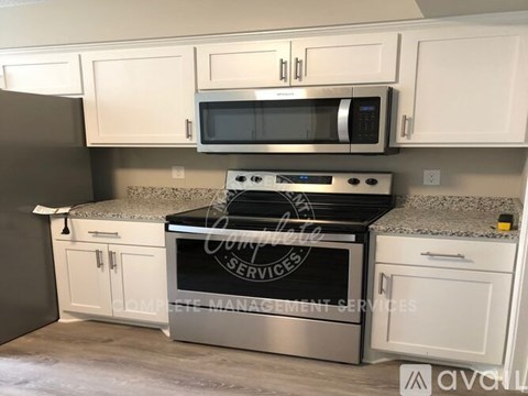 A kitchen with white cabinets and a stainless steel oven.