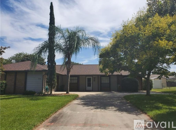 A house with a driveway and trees in front.