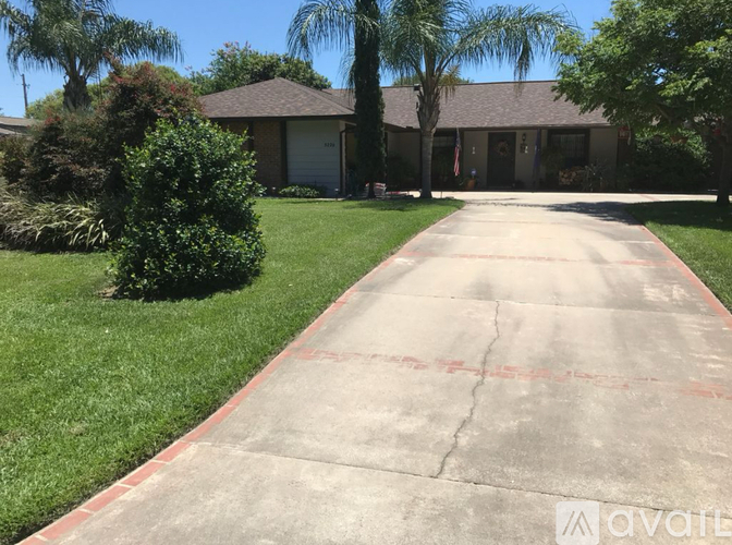A driveway leads to a house with a garage.
