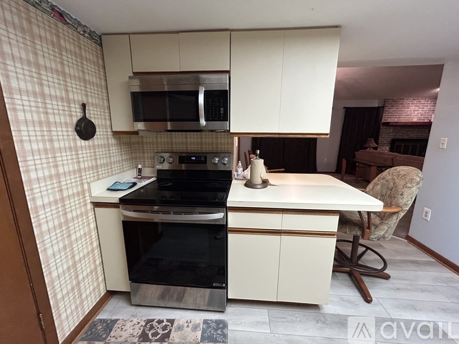 A kitchen with a black oven and a black microwave above a black stove.