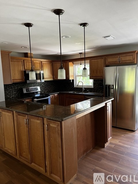 A kitchen with wooden cabinets and a granite countertop.