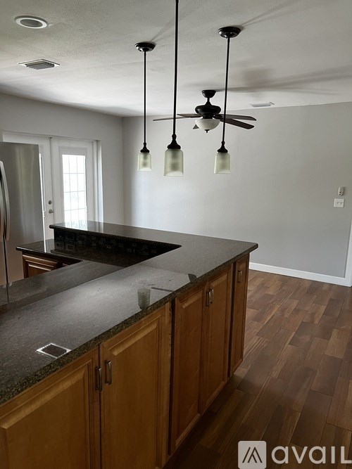 A kitchen with wooden cabinets and a granite countertop.