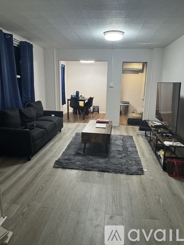 A living room with a black couch and a coffee table.