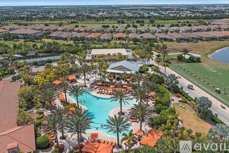 A bird's eye view of a resort with a pool and palm trees.