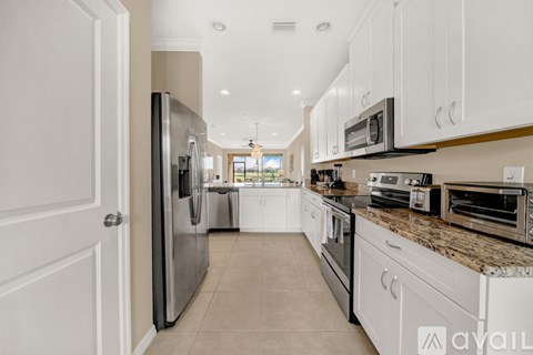 A kitchen with white cabinets and appliances.