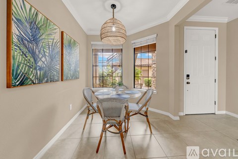 A dining room with a table set for four and a painting on the wall.