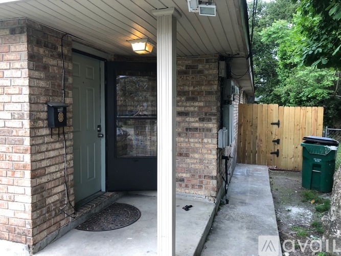 A house with a green door and a brick wall.